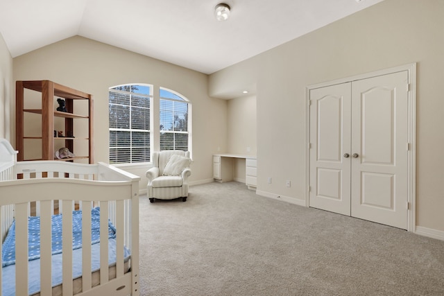 unfurnished bedroom with carpet, baseboards, vaulted ceiling, and a closet