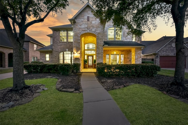 view of front of home featuring stone siding and a lawn