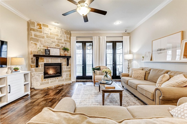 living room featuring french doors, a fireplace, ornamental molding, a ceiling fan, and wood finished floors