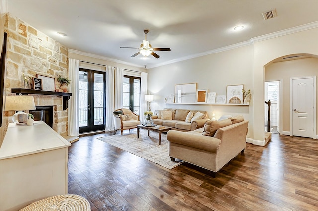 living room featuring arched walkways, french doors, crown molding, dark wood finished floors, and visible vents