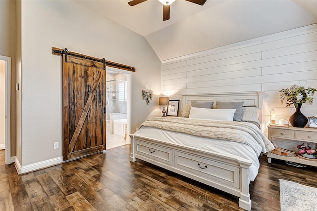 bedroom featuring dark wood-style flooring, a barn door, a ceiling fan, connected bathroom, and vaulted ceiling