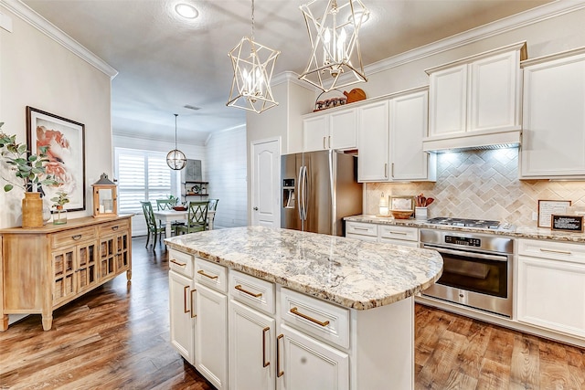 kitchen with a center island, pendant lighting, crown molding, light wood finished floors, and appliances with stainless steel finishes