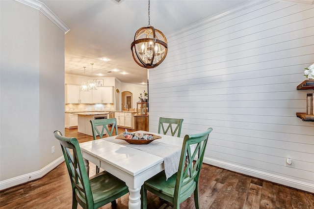 dining room with arched walkways, baseboards, dark wood-style floors, and an inviting chandelier