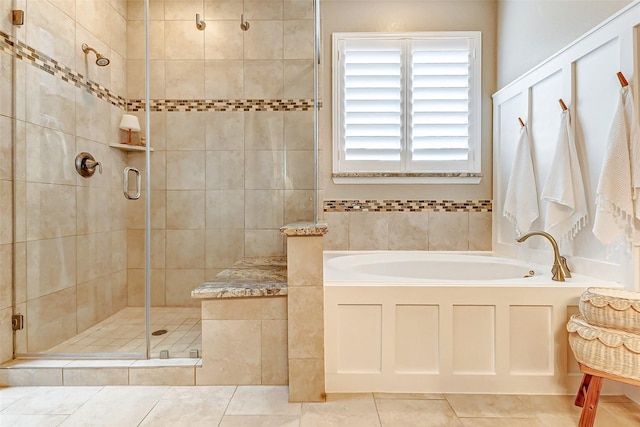 bathroom featuring a stall shower, tile patterned flooring, and a garden tub