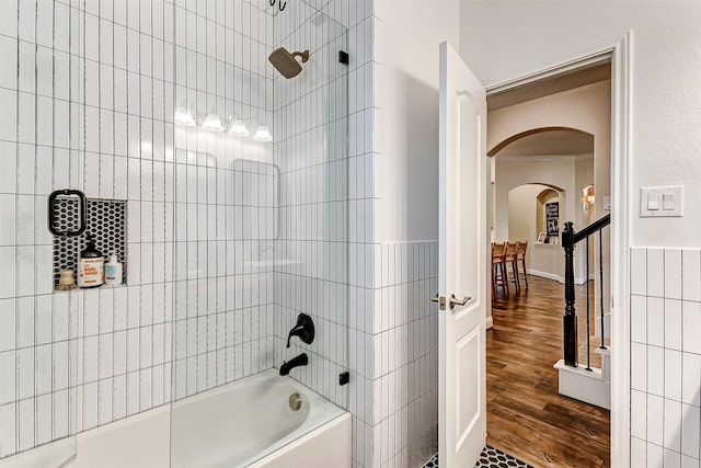 full bath featuring shower / washtub combination, tile walls, and wood finished floors