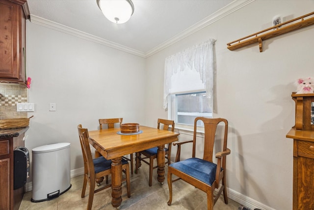 dining room with ornamental molding and baseboards