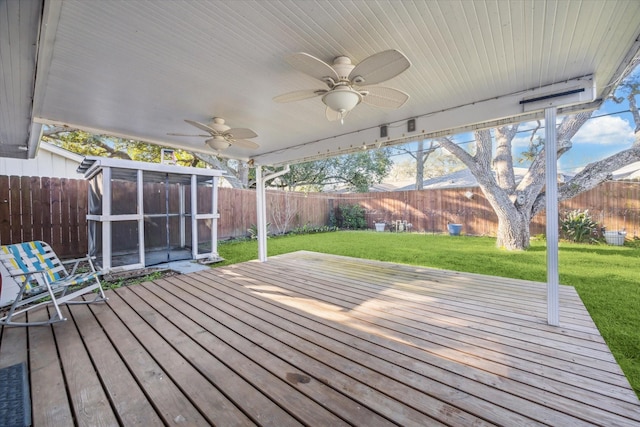 wooden terrace with a fenced backyard, ceiling fan, and a yard