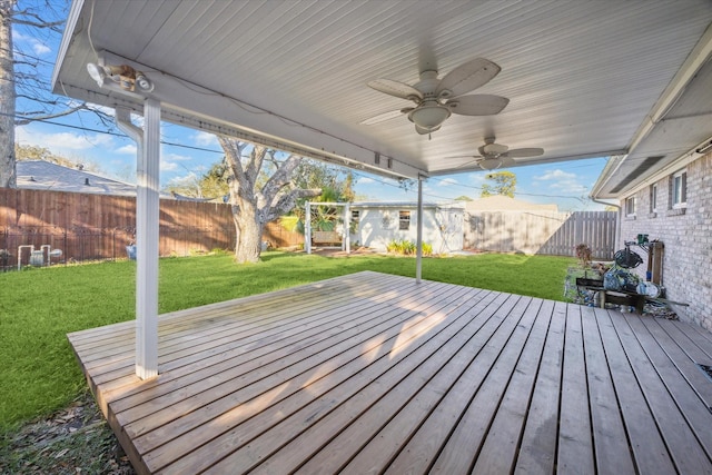 deck featuring a fenced backyard, a lawn, and ceiling fan