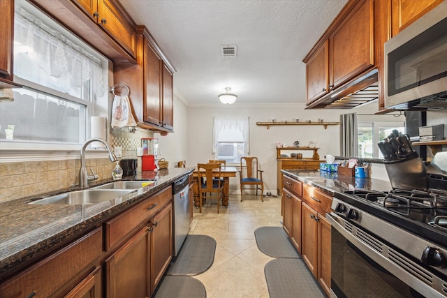 kitchen with light tile patterned floors, tasteful backsplash, visible vents, stainless steel appliances, and a sink