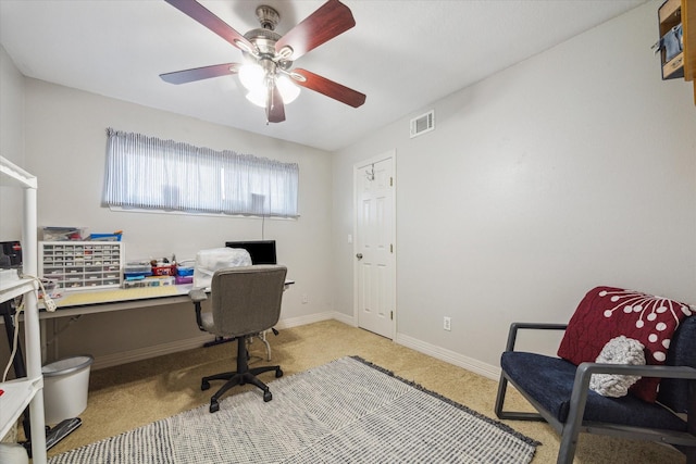 office space featuring visible vents, ceiling fan, light colored carpet, and baseboards