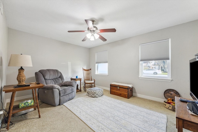 living area with carpet flooring, a ceiling fan, and baseboards