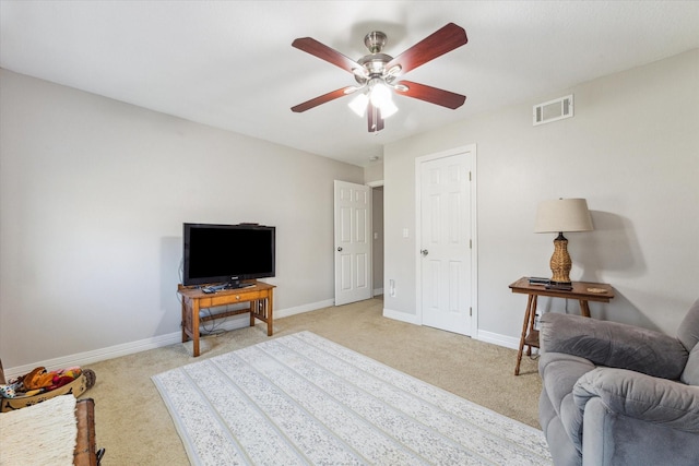 sitting room featuring baseboards, a ceiling fan, visible vents, and light colored carpet