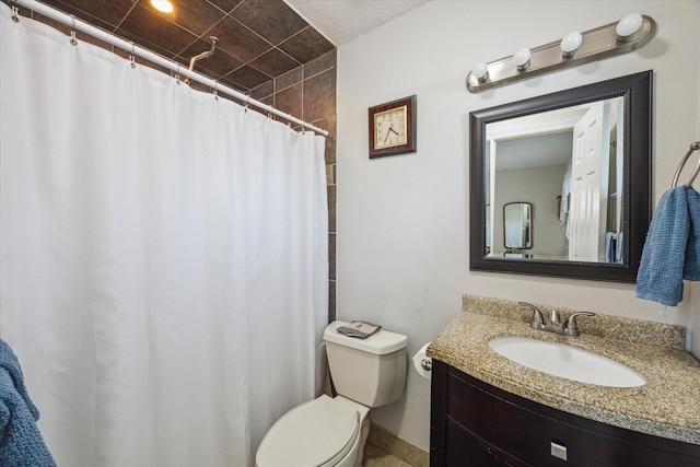 full bathroom featuring toilet, tiled shower, and vanity