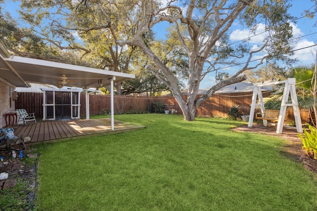 view of yard with a fenced backyard, an outdoor structure, a wooden deck, and a storage unit