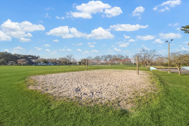 view of home's community featuring volleyball court and a lawn