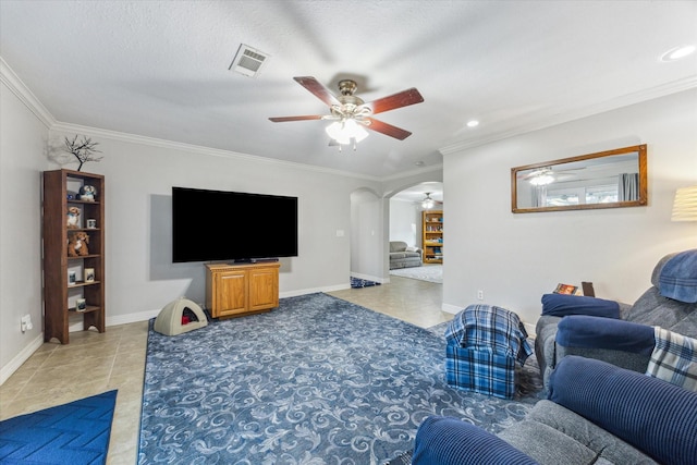 living room with light tile patterned floors, visible vents, arched walkways, and crown molding