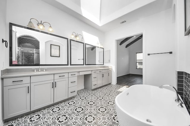 full bath with a sink, visible vents, vaulted ceiling, a soaking tub, and double vanity