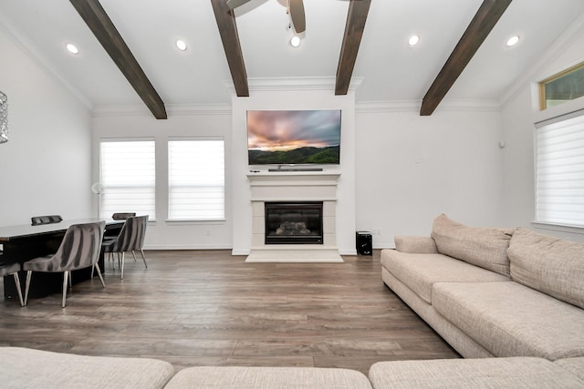 living room featuring a glass covered fireplace, crown molding, lofted ceiling with beams, and wood finished floors