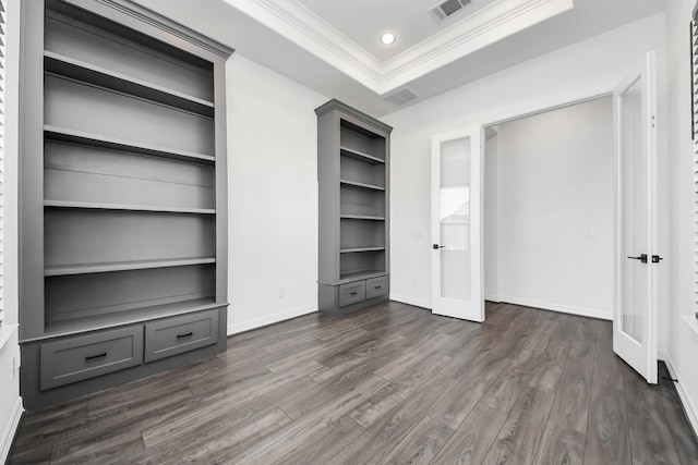 unfurnished bedroom with recessed lighting, dark wood-style flooring, visible vents, ornamental molding, and a tray ceiling