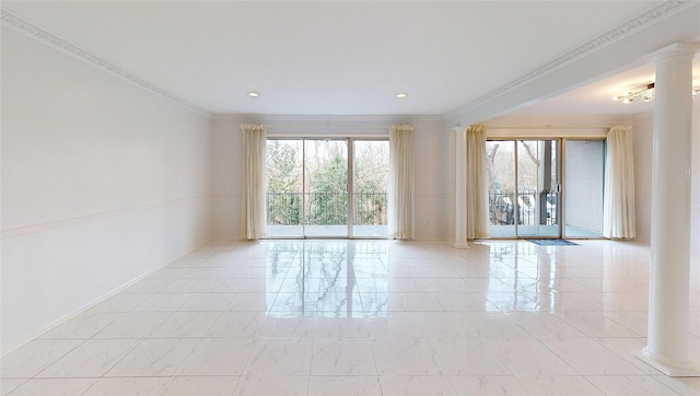 empty room featuring crown molding and decorative columns