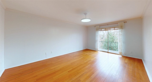 spare room with crown molding, light wood-style flooring, and baseboards