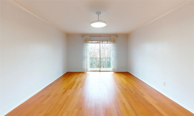 spare room featuring light wood-type flooring, baseboards, and ornamental molding