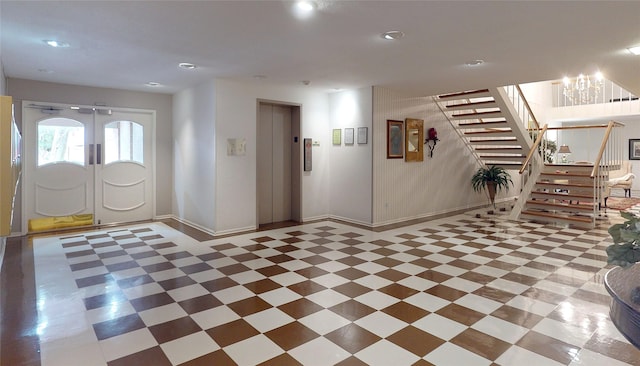 entrance foyer with elevator, baseboards, french doors, and stairs