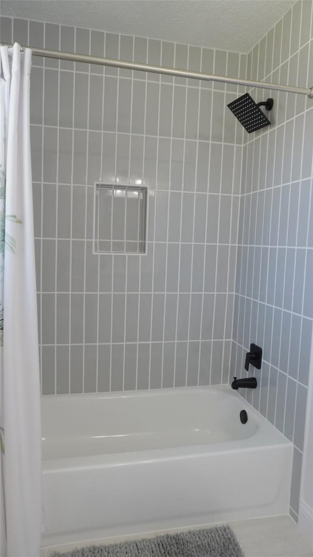 full bathroom featuring a textured ceiling and shower / bath combination with curtain