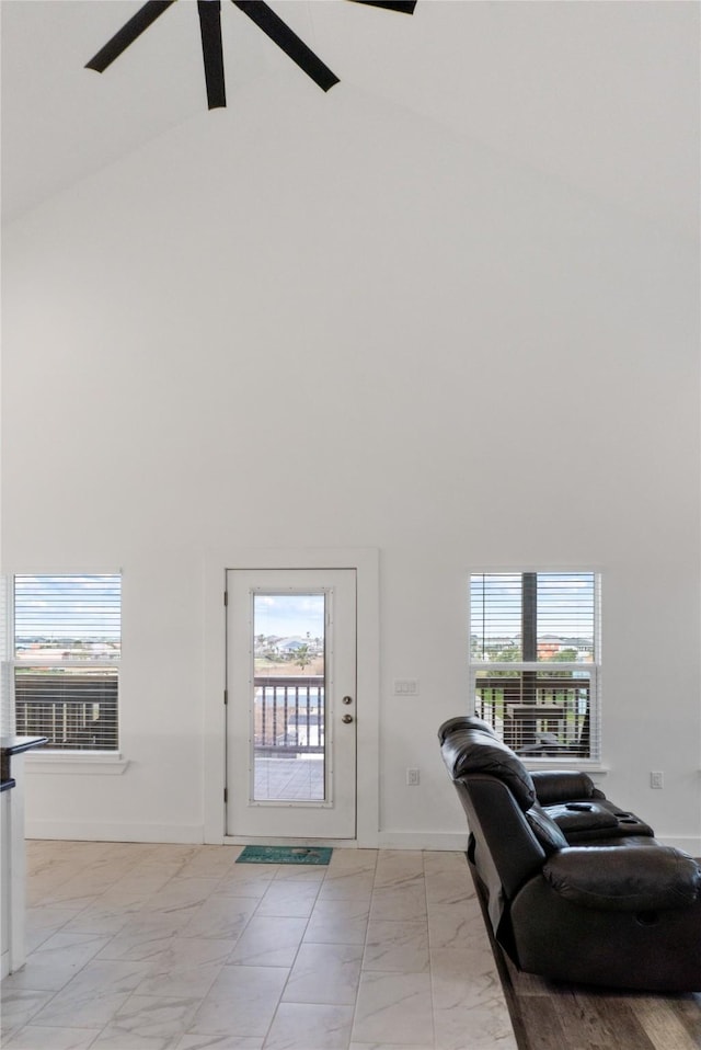 foyer featuring marble finish floor, ceiling fan, high vaulted ceiling, and baseboards