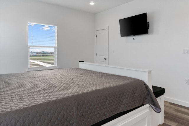 bedroom featuring baseboards, wood finished floors, and recessed lighting