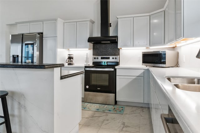 kitchen with tasteful backsplash, wall chimney exhaust hood, marble finish floor, stainless steel appliances, and a sink