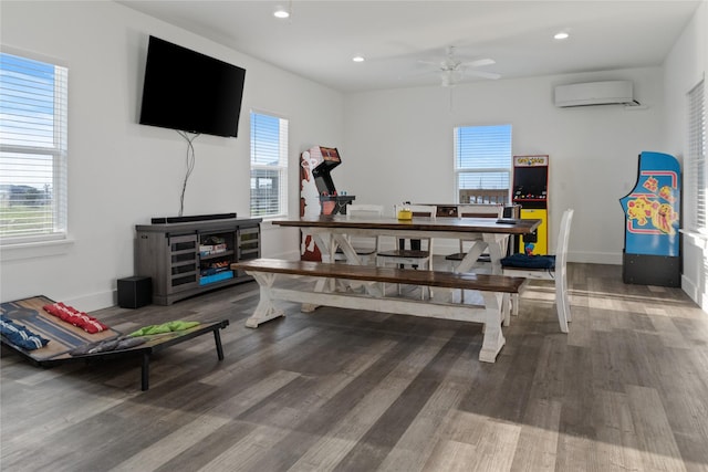 rec room featuring recessed lighting, a wall unit AC, baseboards, and wood finished floors