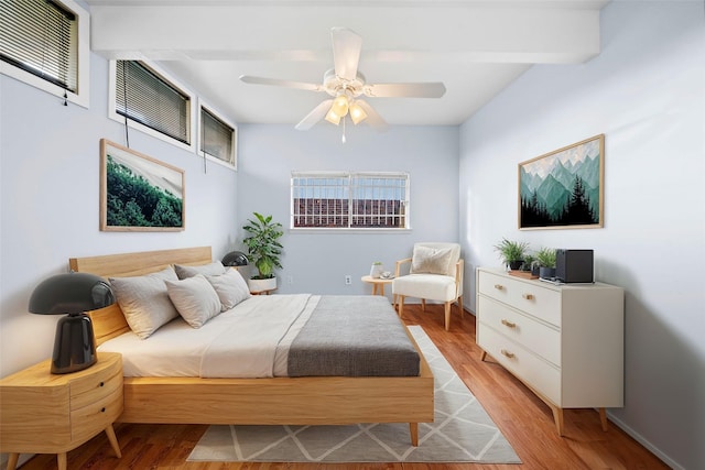 bedroom featuring ceiling fan, light wood-style flooring, and baseboards