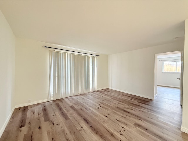 unfurnished room with wood finished floors and baseboards