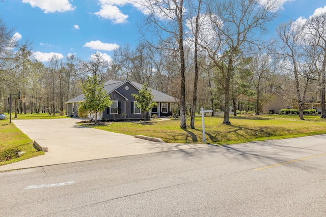 view of front of house with driveway and a front lawn