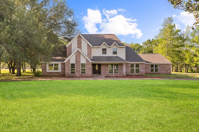 view of front of property with brick siding, a front lawn, and roof with shingles