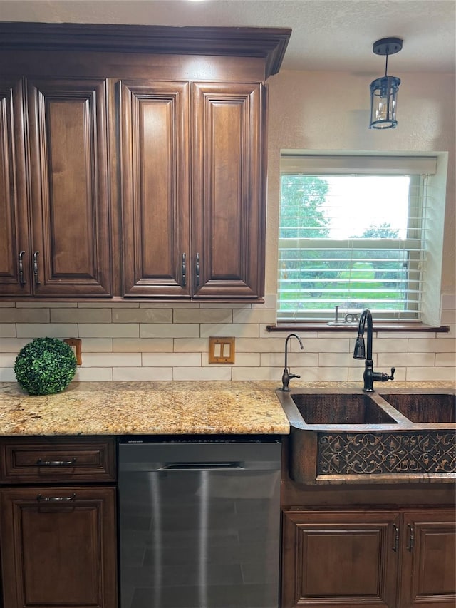 kitchen featuring light stone counters, tasteful backsplash, stainless steel dishwasher, a sink, and dark brown cabinetry