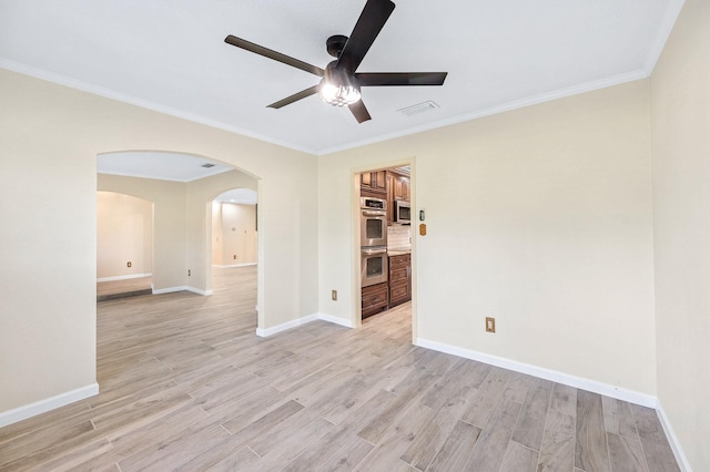 unfurnished room with arched walkways, baseboards, visible vents, and light wood finished floors