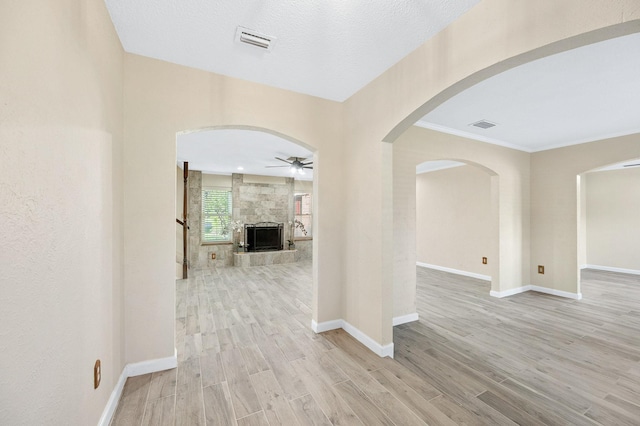 hall featuring light wood-type flooring, baseboards, and visible vents