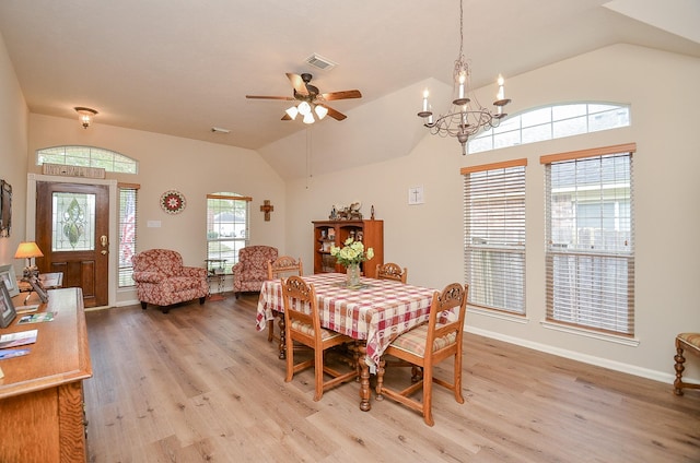 dining room with visible vents, vaulted ceiling, light wood-type flooring, baseboards, and ceiling fan with notable chandelier