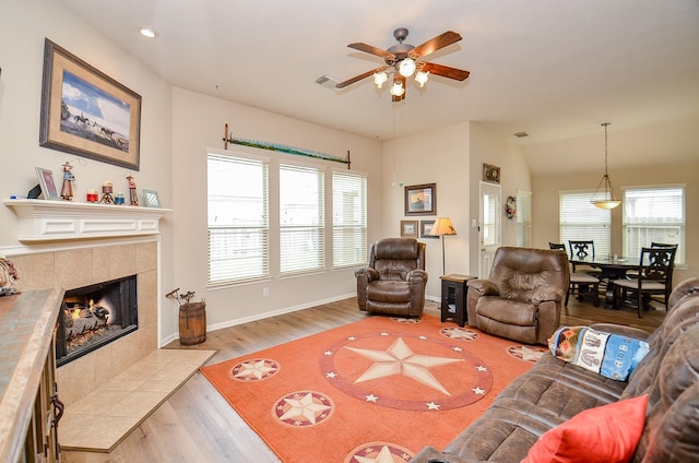 living area with visible vents, baseboards, light wood-style floors, a fireplace, and recessed lighting