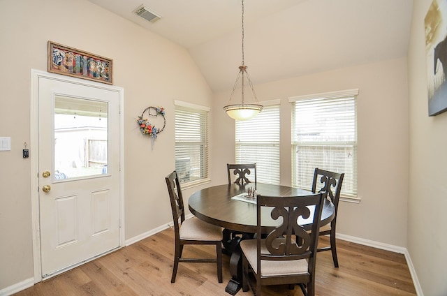 dining room featuring visible vents, vaulted ceiling, light wood-style flooring, and baseboards