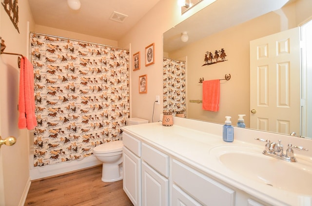 full bath featuring visible vents, vanity, toilet, and wood finished floors