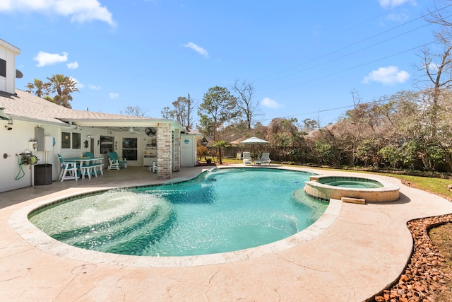 view of pool with a patio area, fence, and a pool with connected hot tub