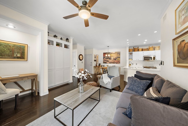 living room featuring ceiling fan, recessed lighting, dark wood-type flooring, visible vents, and ornamental molding