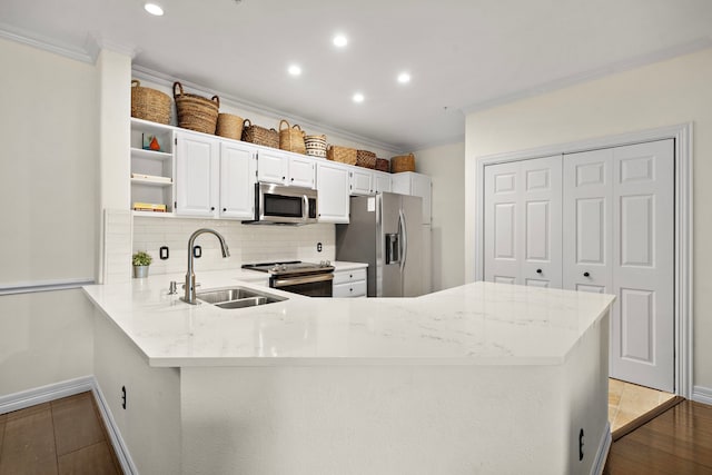 kitchen featuring ornamental molding, open shelves, appliances with stainless steel finishes, and a sink