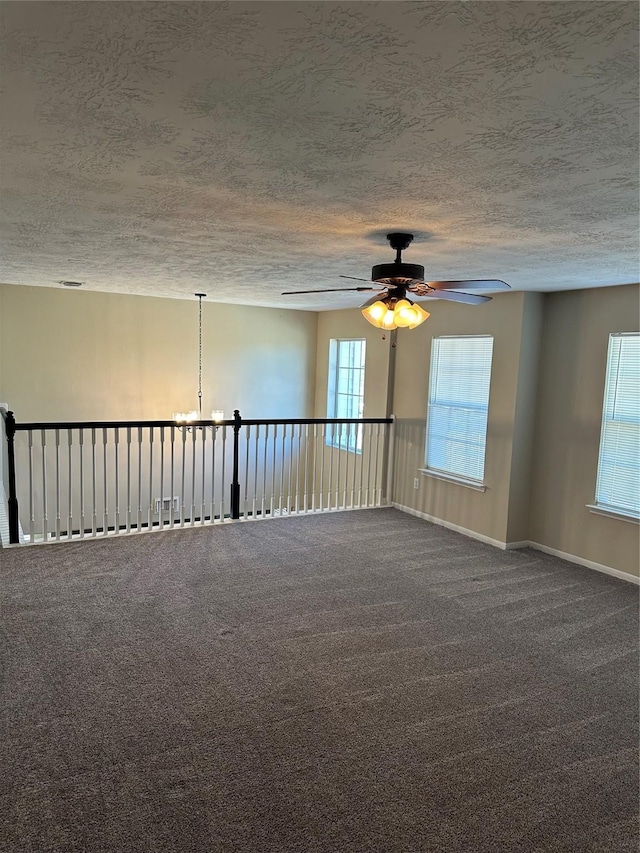 carpeted empty room with ceiling fan and a textured ceiling