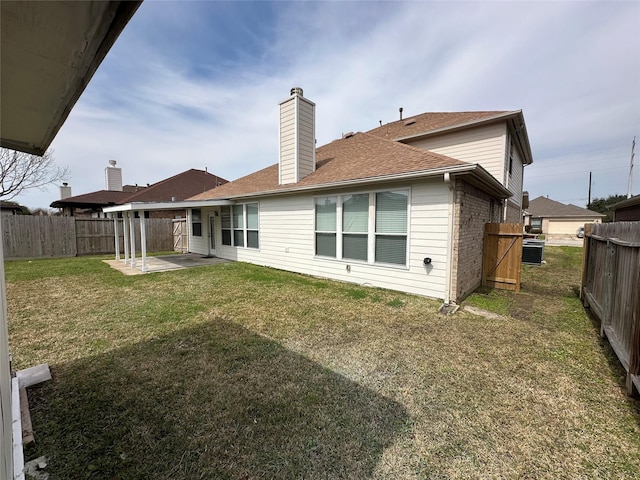 back of property with a patio area, brick siding, a lawn, and a fenced backyard