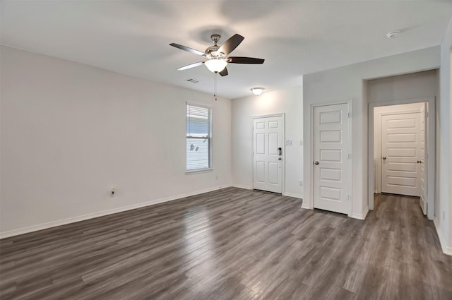 unfurnished room featuring a ceiling fan, visible vents, baseboards, and dark wood-type flooring