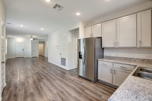 kitchen featuring a sink, visible vents, stainless steel refrigerator with ice dispenser, and light countertops